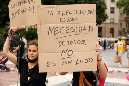 Protesters hold a sign reading 'Electricity is a necessity for all, not a luxury' (by Arnald Prat)