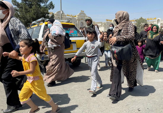 Women and children try to get to Kabul airport to flee Afghanistan after the Taliban took control of the city, August 2021 (Reuters)