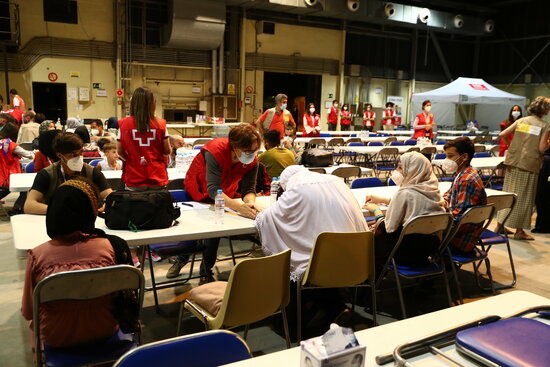 Afghan refugees are assisted by Red Cross staff in Spain's Torrejón de Ardoz military airport (by Fernando Calvo-Moncloa)