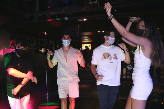 A group of young people dancing with masks on at Flashback in Salou, June 23, 2021 (by Ariadna Escoda) 