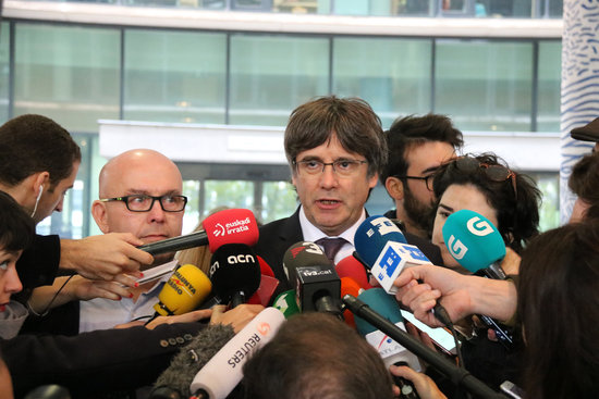 Former Catalan president Carles Puigdemont speaks to the media alongside his lawyer Gonzalo Boye outside a courtroom in Brussels in October 2019