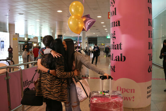 A family hugs after their reunion in the airport after restrictions were lifted to allow friends and family to enter the facility (by Gemma Sánchez)