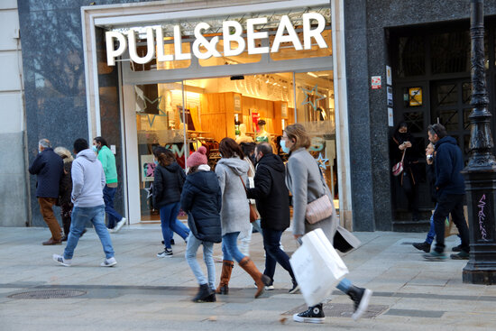 Buyers walk in front of a shop in Barcelona on December 8, 2021 (by Jordi Bataller)