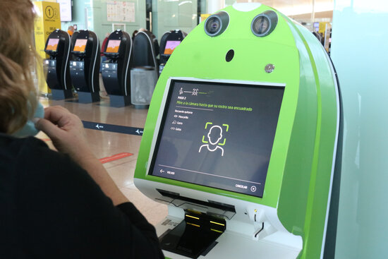 A passenger checks in for their flight in Barcelona airport using facial recognition technology as part of a trial from airline Vueling (by Lluís Sibils)