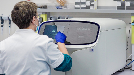 An oncologist looks at a machine to examine a tumor (image from Catalan Health Department)