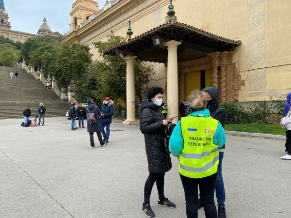 A translator assists people at the Ukrainian refugee welcome site outside the Fira de Barcelona congress hall (by Gerard Escaich Folch)