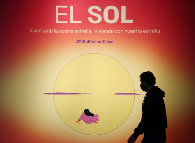 A man walks in front of a poster at CosmoCaixa's exhibition on the Sun, March 22, 2022 (by Pau Cortina) 