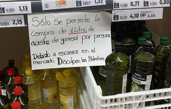 A sign indicating that customers in a supermarket can only purchase a maximum of 1 litre each of sunflower oil (by Cristina Tomàs White)