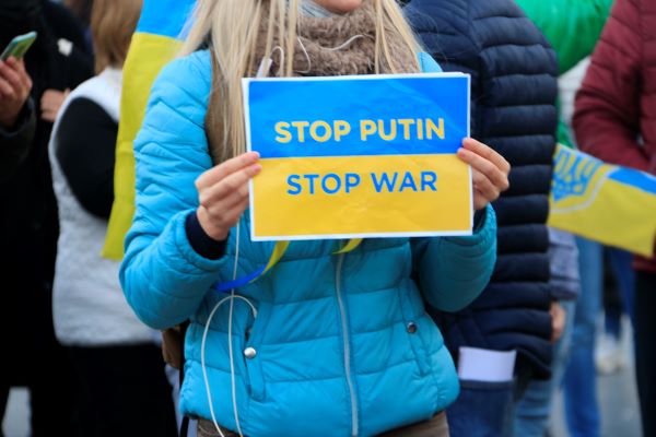 A Ukrainian protester holds up an anti-war sign (by Laura Fíguls)