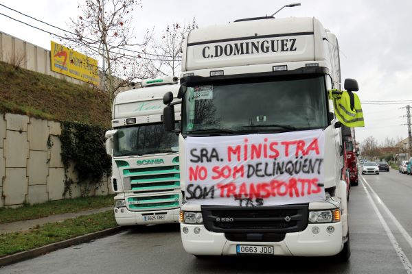 Protesting truckers hang a sign in front of one of their vehicles (by Nia Escolà)