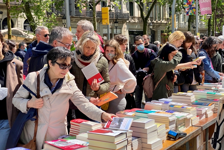 People looking at books at a stall on Passeig de Gràcia in Barcelona on April 23, 2022