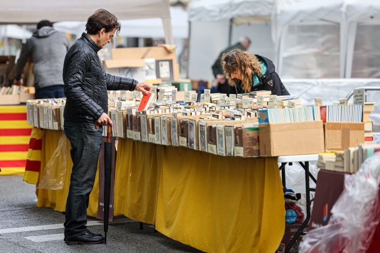 A reader checks some books in Passeig de Gràcia during Sant Jordi on April 23, 2022 (by Jordi Borràs)