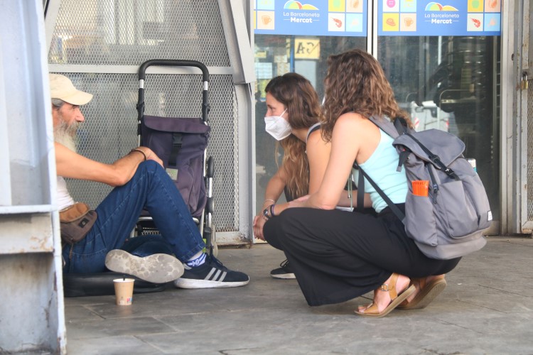 Arrels Foundation staff talk to a homeless person outside Barceloneta market, August 13, 2021 (by Albert Cadanet)