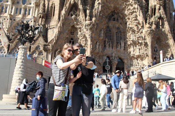 Tourists take a selfie in front of the Sagrada Família on April 16, 2022 (by Carola López)