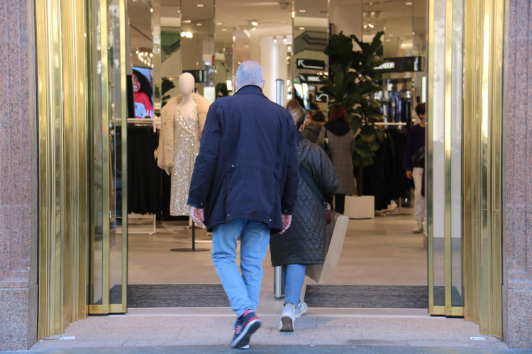 A couple entering a store in Barcelona's Passeig de Gràcia shopping boulevard, on December 19, 2021 (by Eli Don)