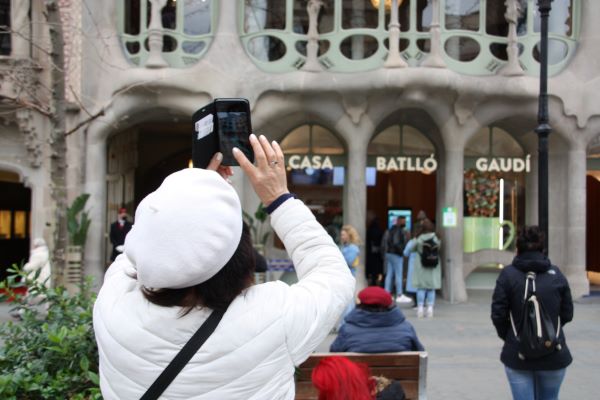 A tourist takes a photograph of Antoni Gaudí's Casa Batlló