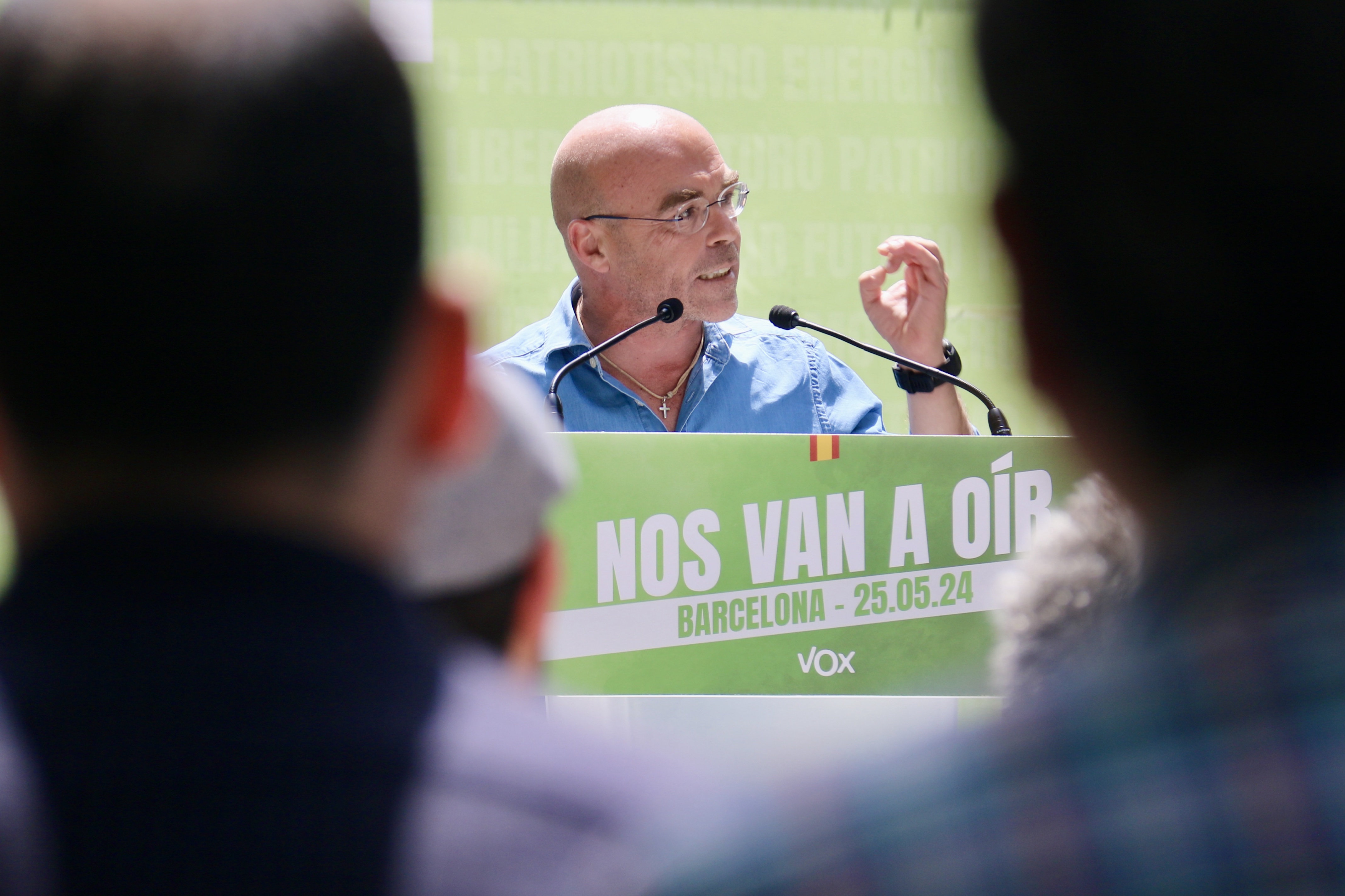 El candidat de Vox a les eleccions europees, Jorge Buxadé, vist entre dos assistents a l'acte principal del partit a Barcelona.