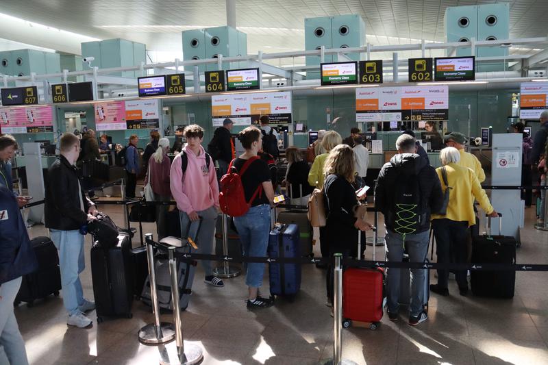 Passengers queuing at a counter at Barcelona airport