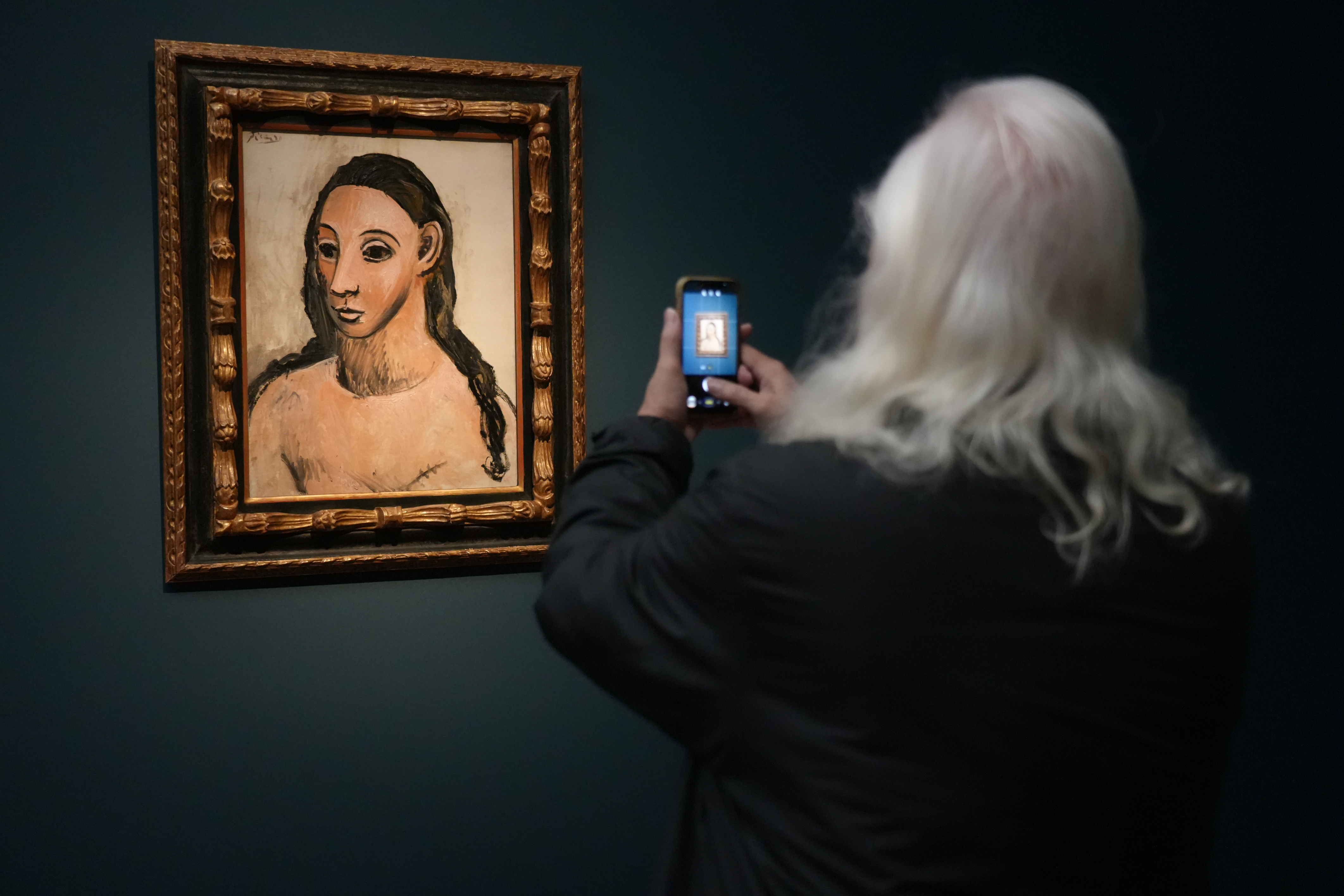 A visitor takes a photograph of one of the works in the exhibition 'Modern Barcelona: From Gaudí to Picasso' at the Kunsthalle München