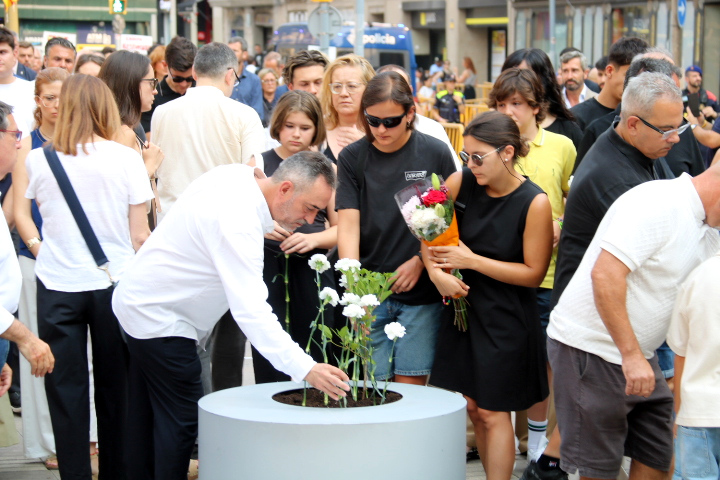 Family members give a floral offering on the anniversary of the 2017 terror attacks