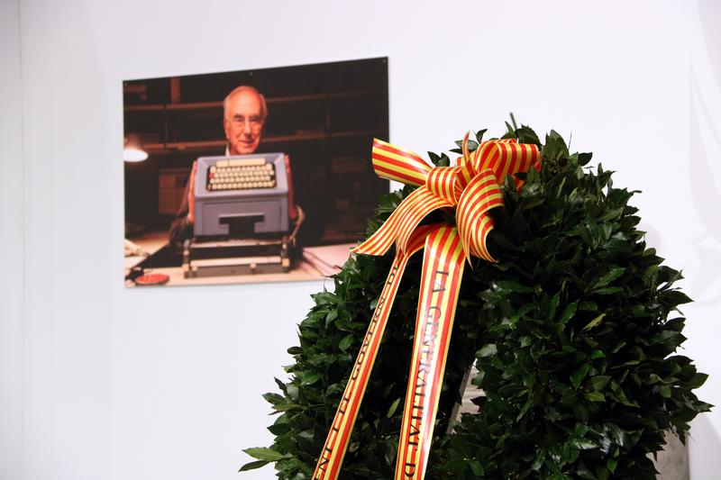 A picture of Josep Maria Espinàs and his typewriter beside the wreath that adorns his casket