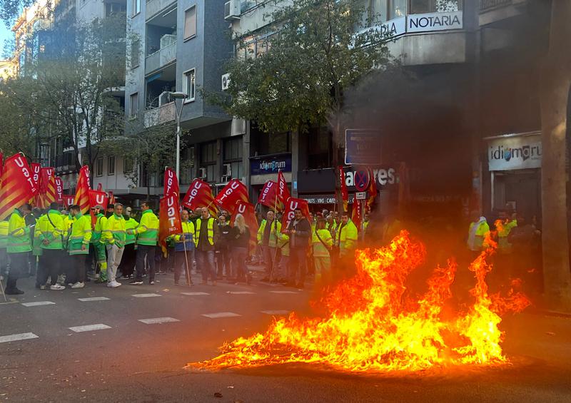 A burning container during a protest outside the Department of Labor as a mediation meeting over street cleaners' Christmas strike takes place