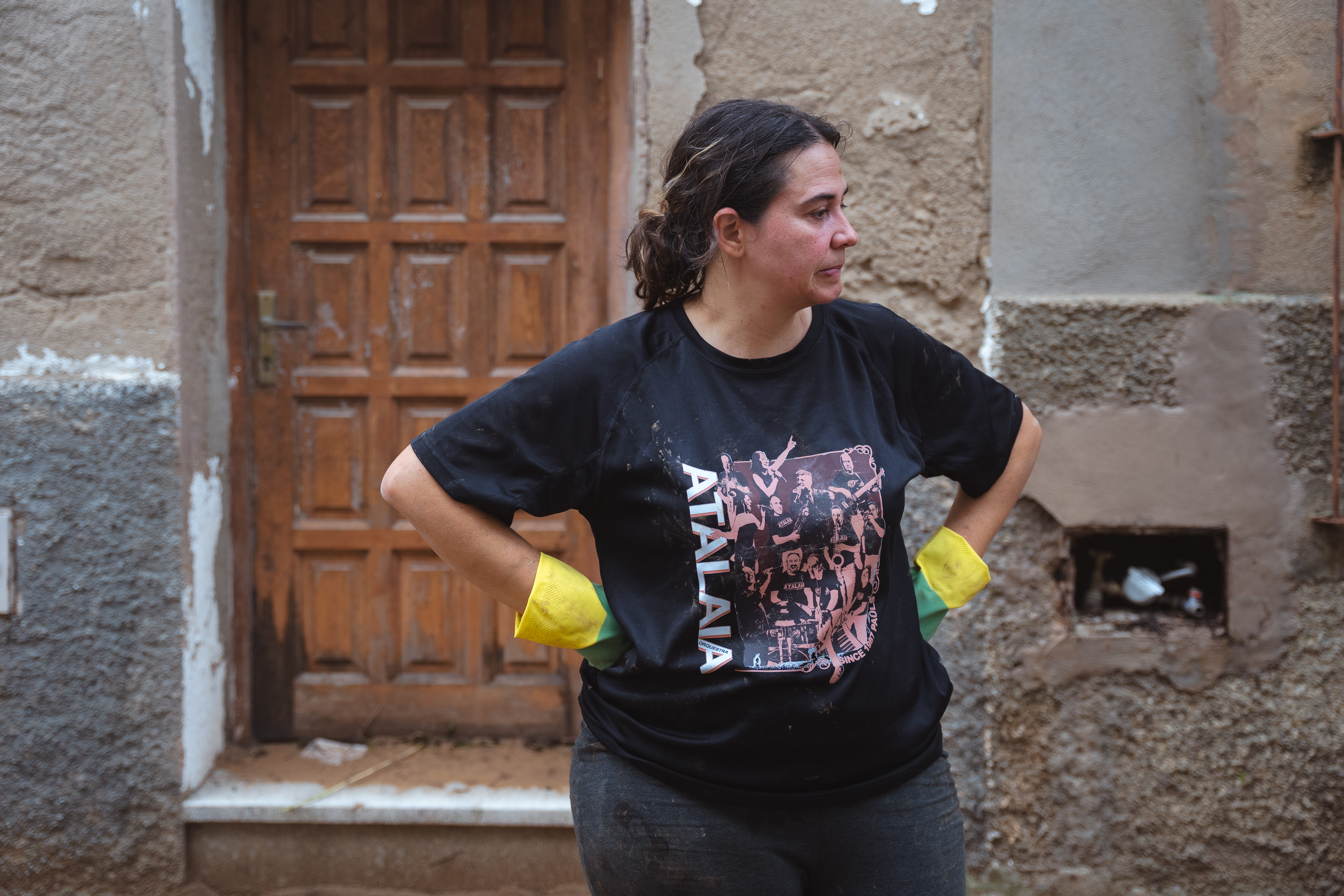 A resident clears mud their home