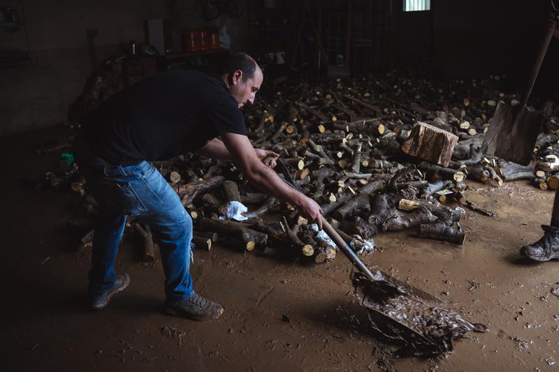 A resident clears mud from a building's ground floor