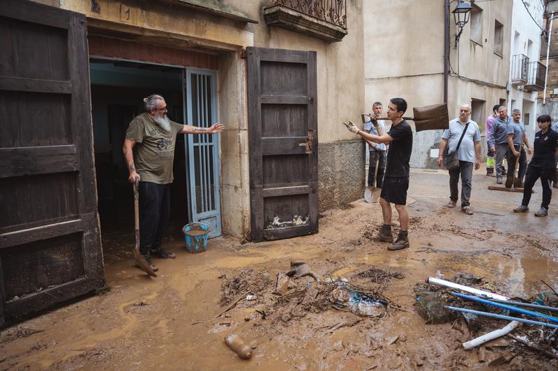 Residents removing mud from a home in Godall, southern Catalonia