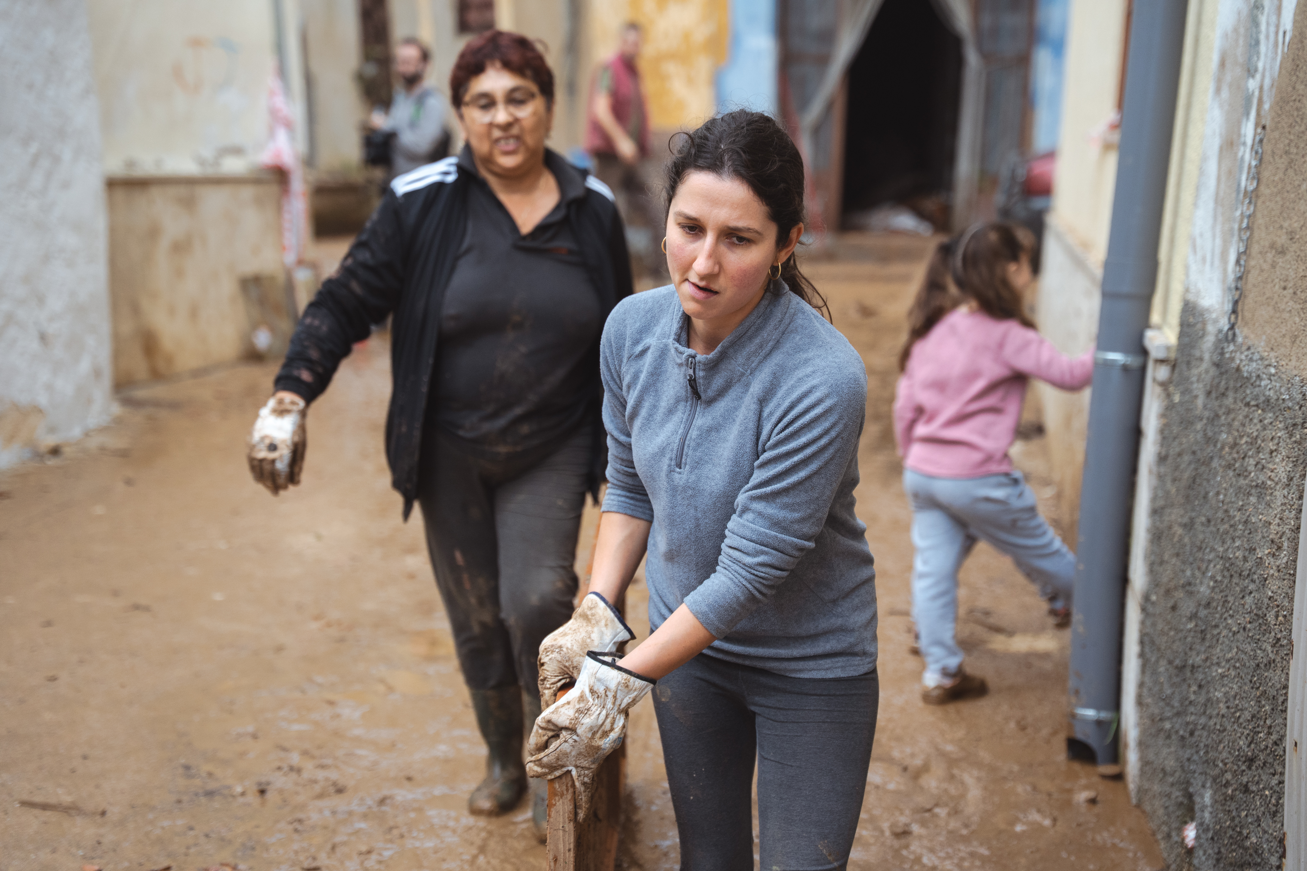Residents clear mud and debris from their homes in Godall, southern Catalonia