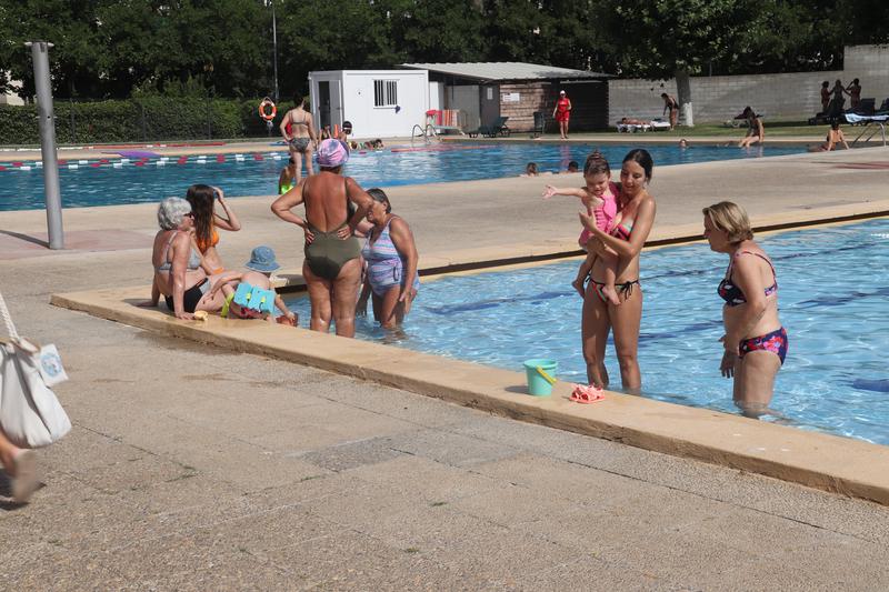 A group of people swimming at the GEiEG de Sant Narcís swimming pool during a heatwave in July 2024