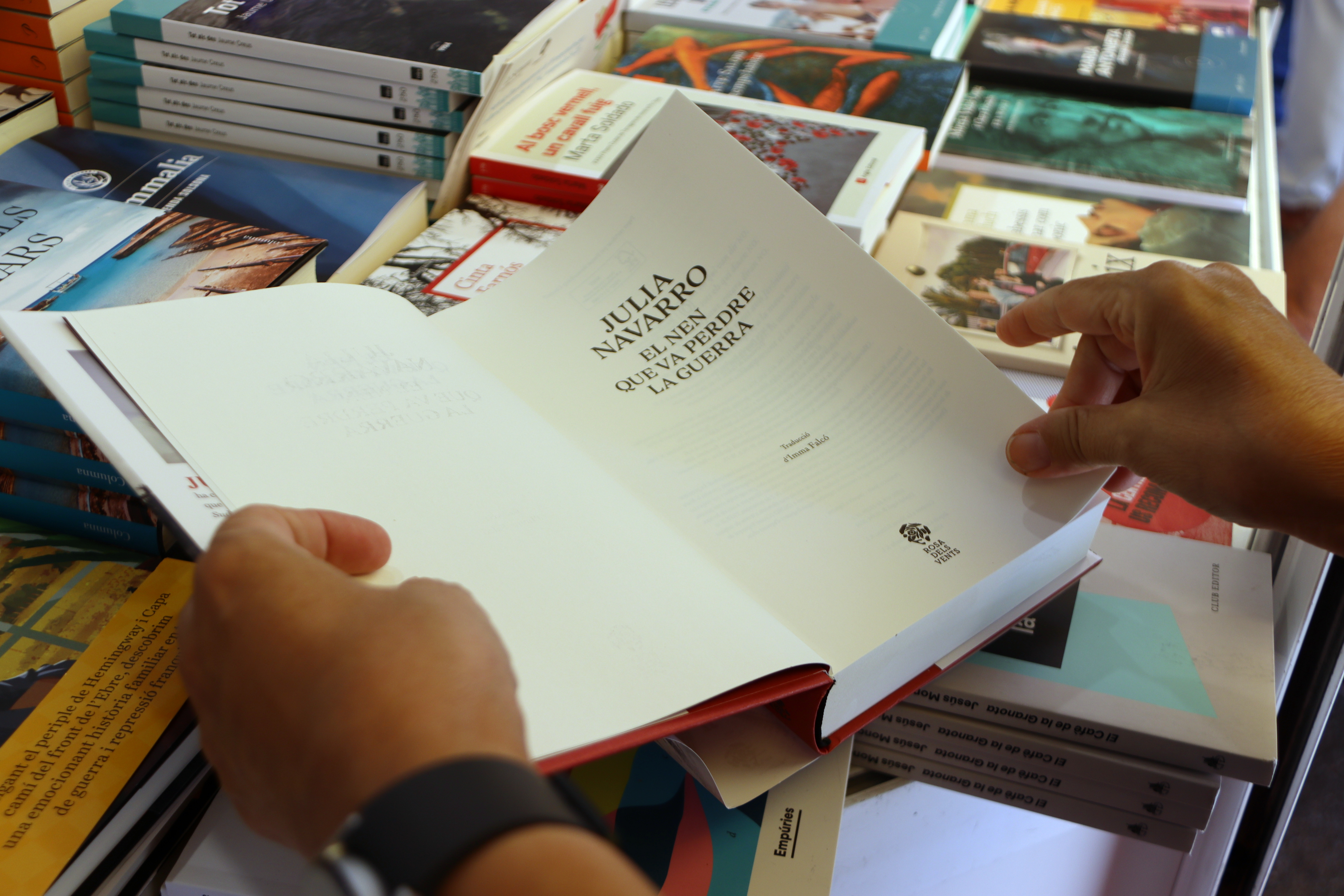 A person browsing a book at one of the stalls of the Catalan Book Week
