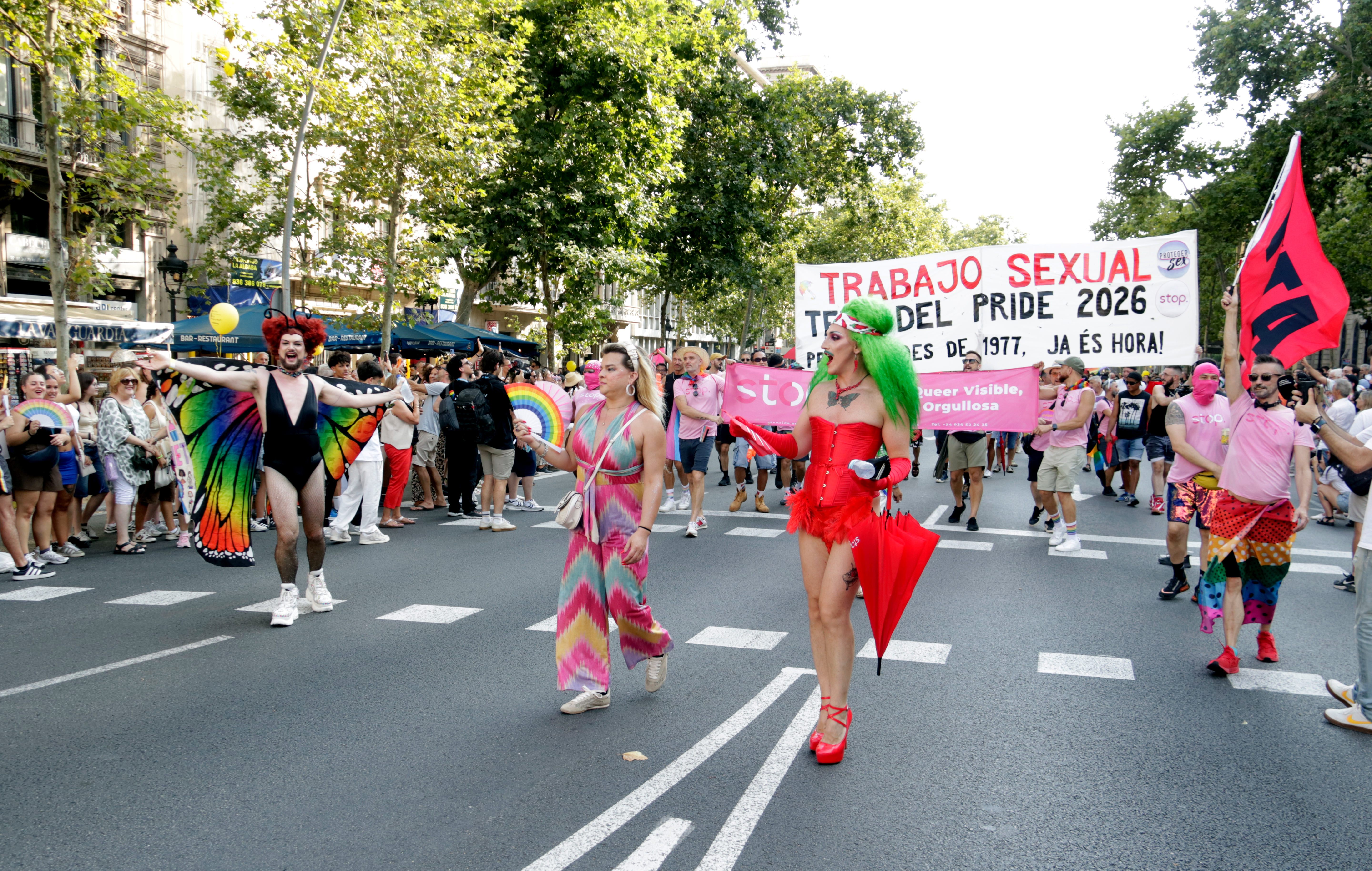 Several attendees at the 2025 Pride demonstration in Barcelona walk down Gran Via boulevard