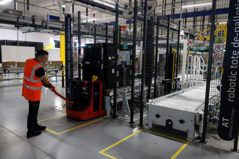An Amazon worker with a distributer robot