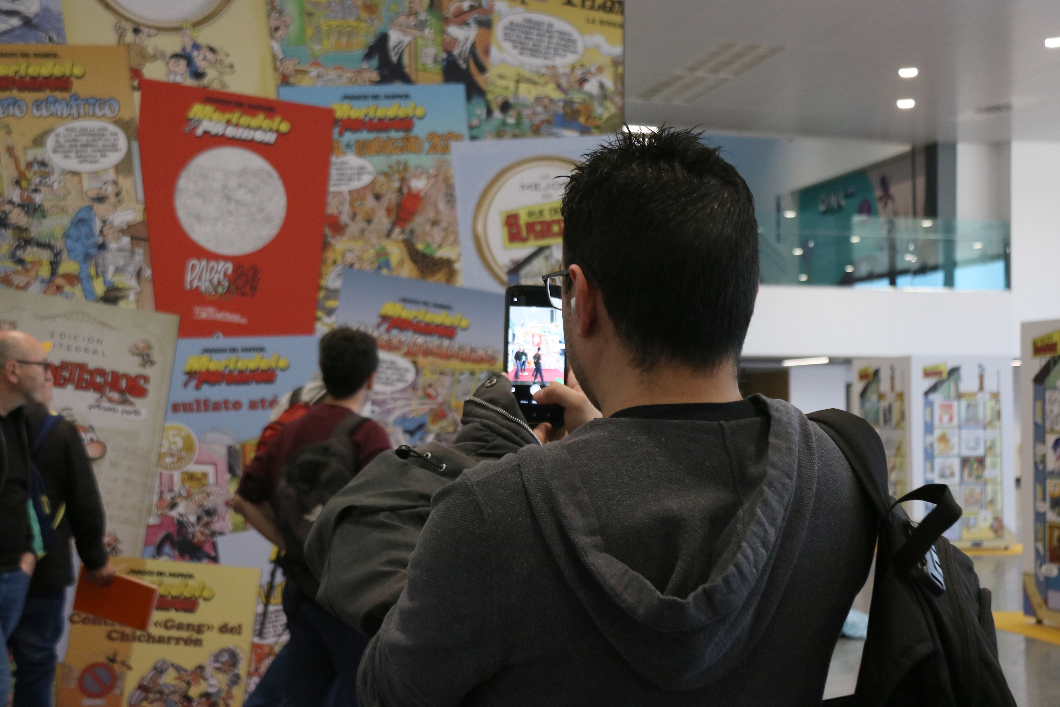 Un visitant del Comic Barcelona fotografiant l'exposició dedicada a Francisco Ibáñez.