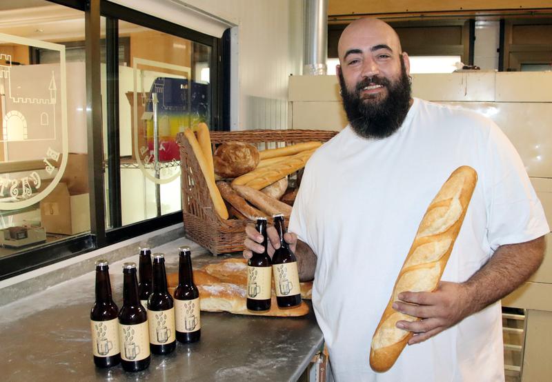 David García in his bakery with some bottles of 'La Panarra' beer.