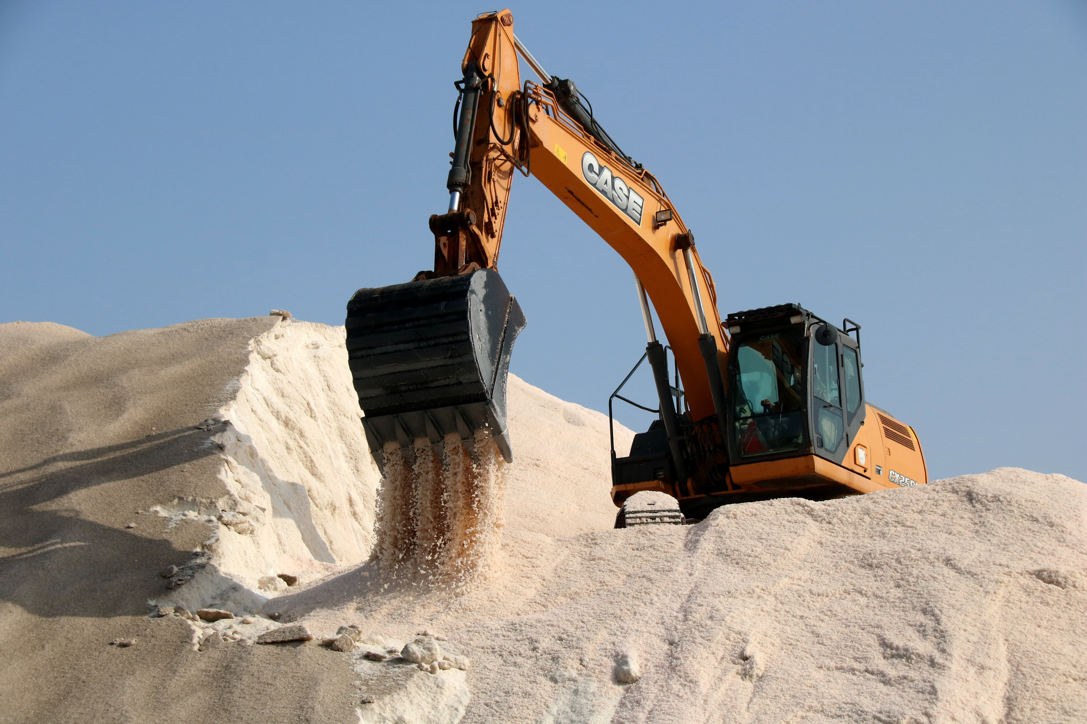 Tractors at work harvesting salt at La Trinitat salt flats in the Ebre Delta, southern Catalonia