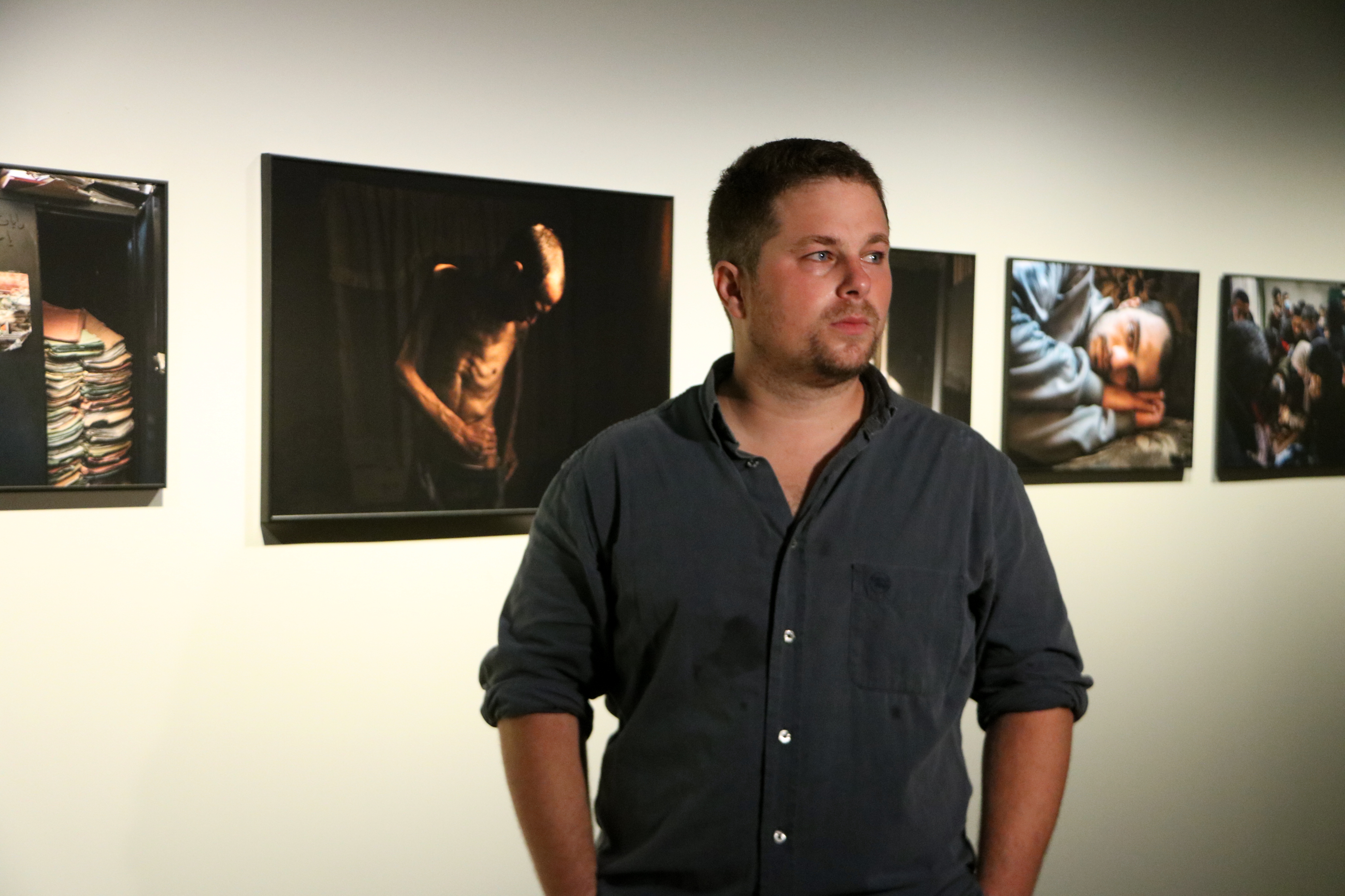 Catalan photographer Samuel Nacar stands in front of his World Press Photo series in the CCCB