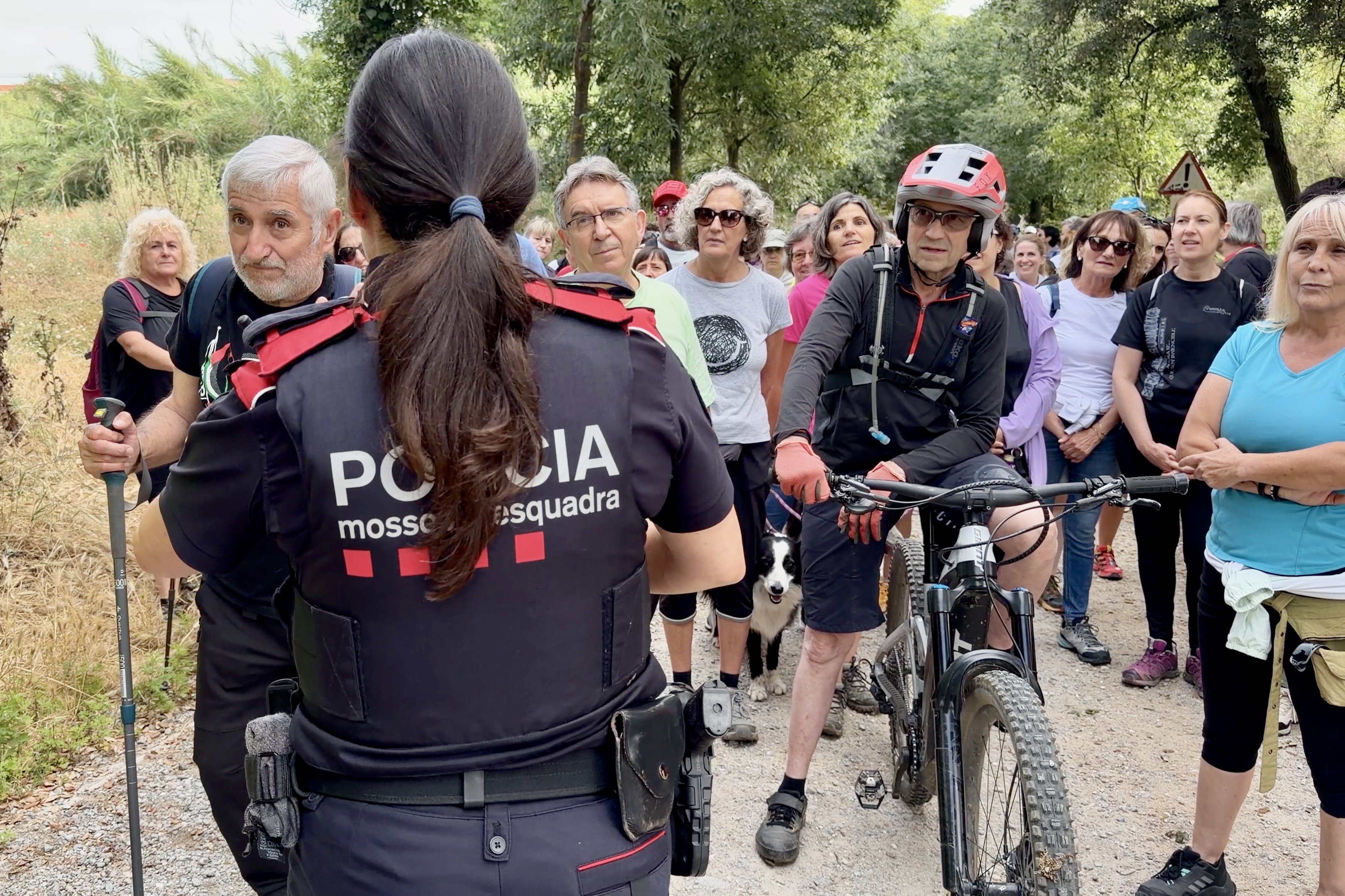 A Mossos d’Esquadra officer attempts to identify participants in a protest walk calling for the reopening of Collserola