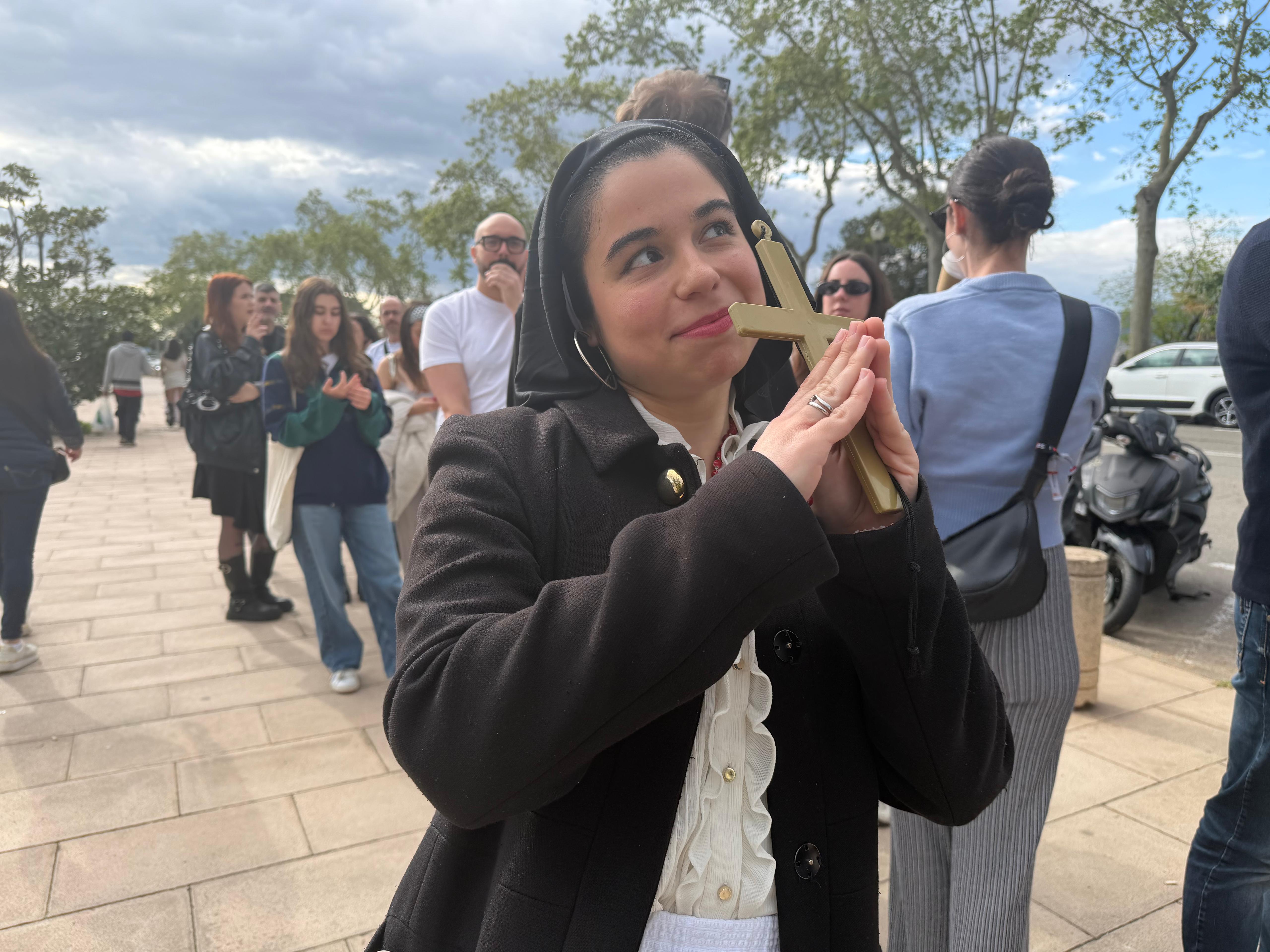 A Rosalía fan poses with a cross and religious garb before the Monday night show in Palau Sant Jordi