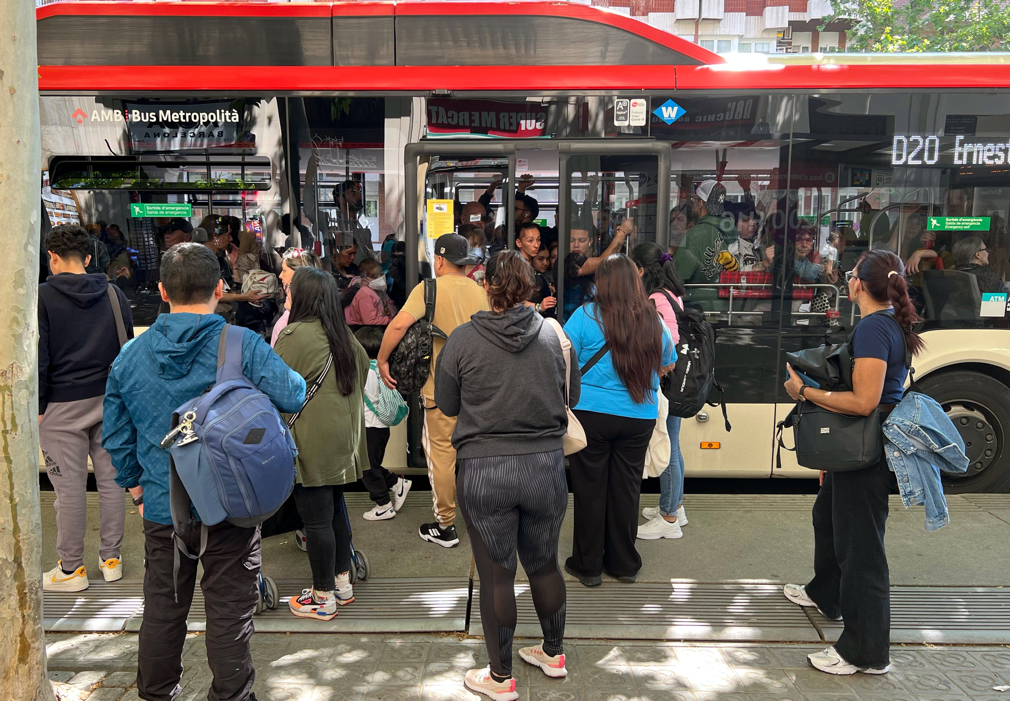 People queue at a bus stop in Barcelona