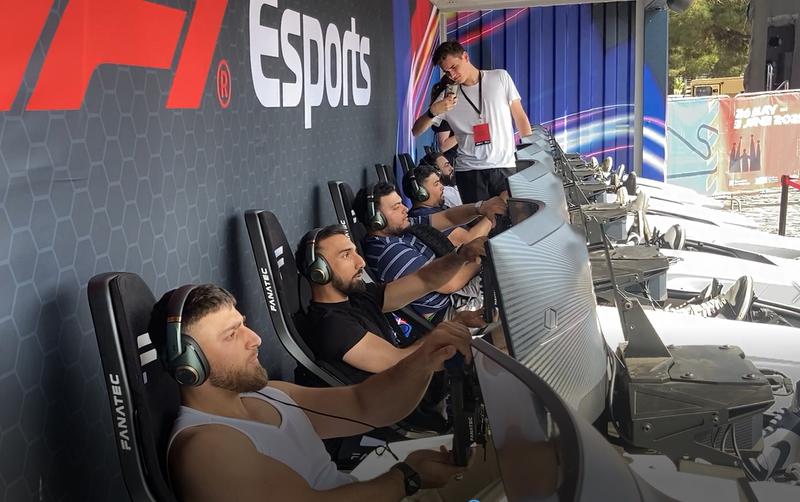 Several people testing the F1 simulators at Formula 1 Barcelona Fan Village on May 26, 2023