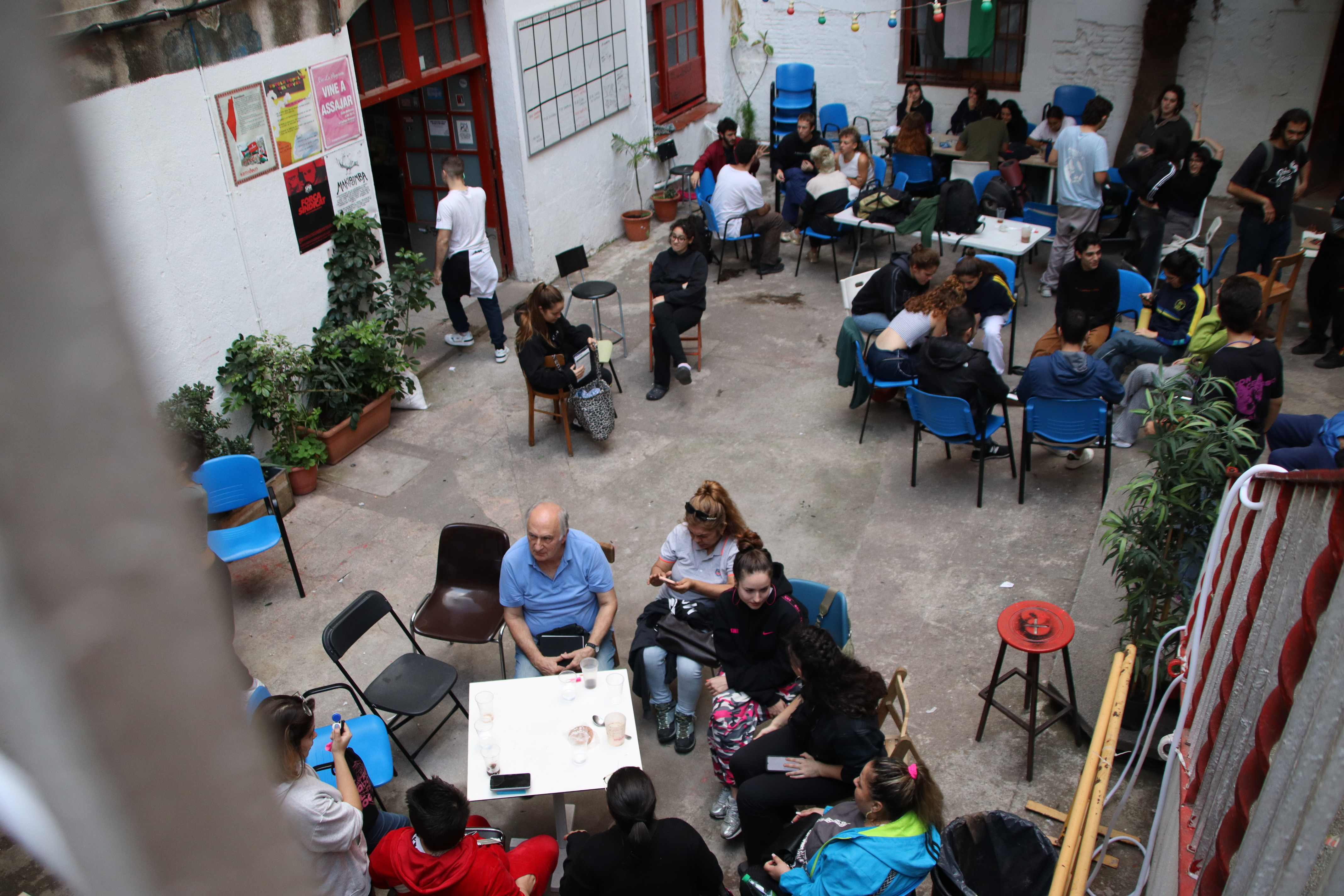 Interior of the Antiga Massana community project with people meeting in groups