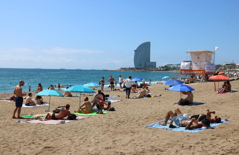 Barceloneta Beach during a lifeguards' strike, with the W Barcelona hotel in the background