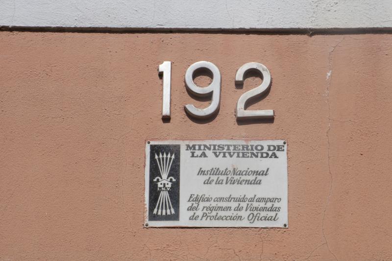 A plaque outside a residency building with Franco-era symbols in Girona