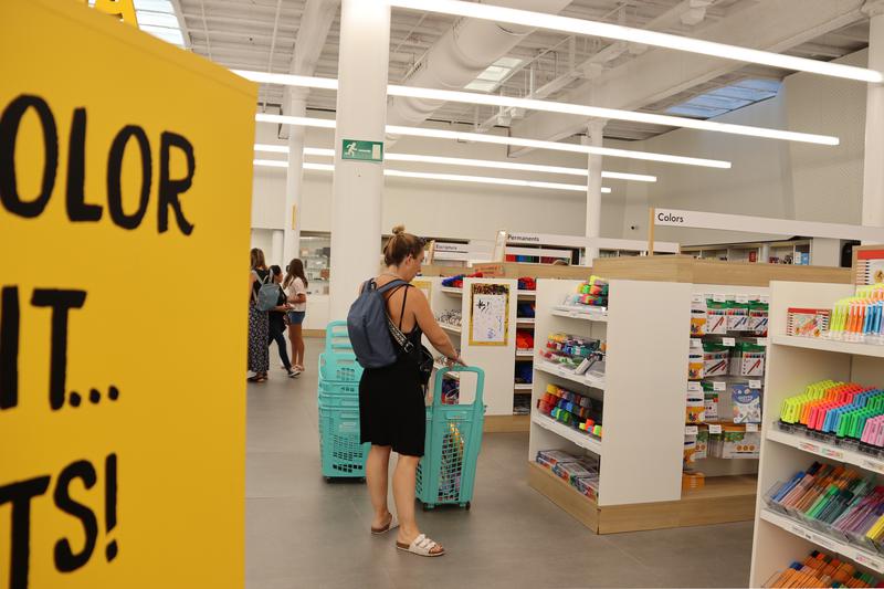 A mother buying material for her child ahead of the new school year