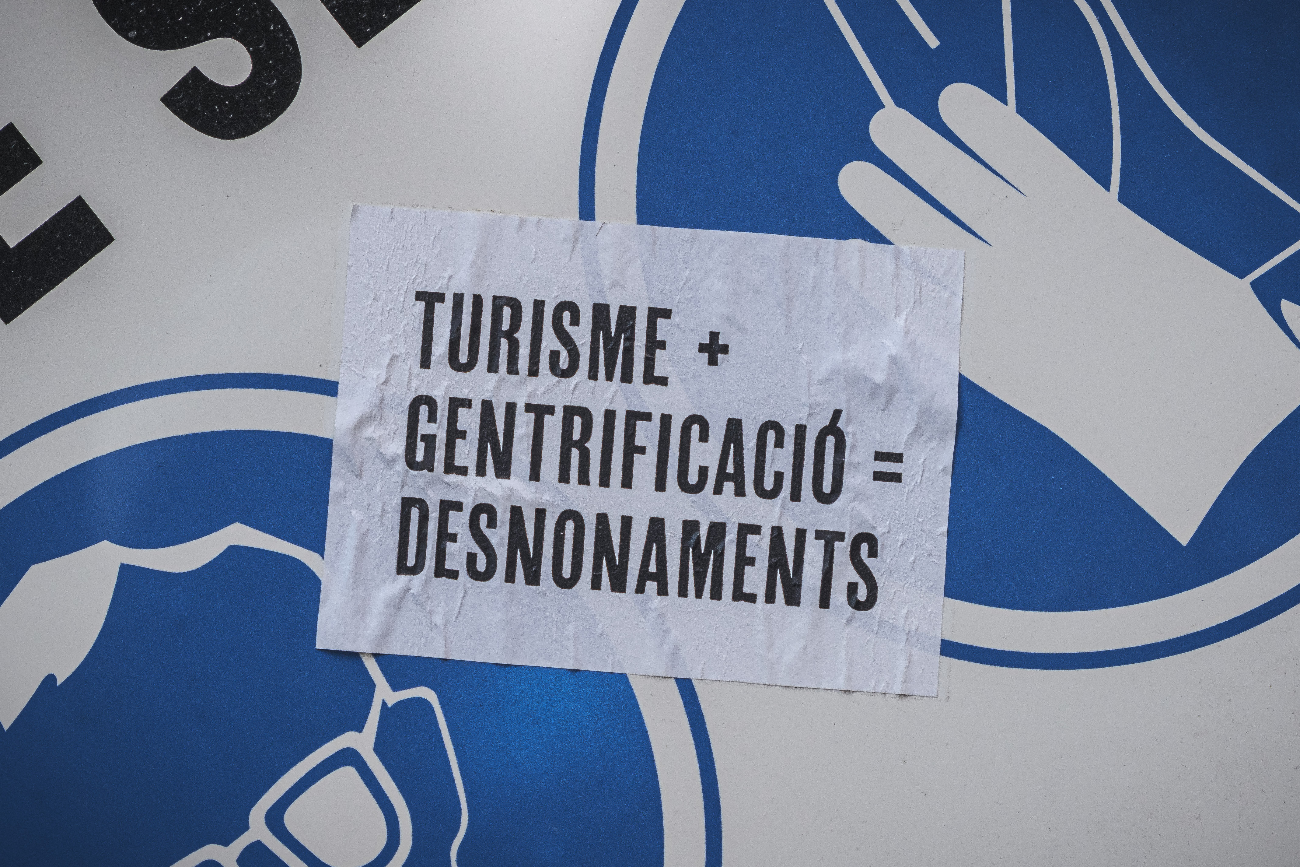 A sticker reading 'Tourism + Gentrification = Evictions'