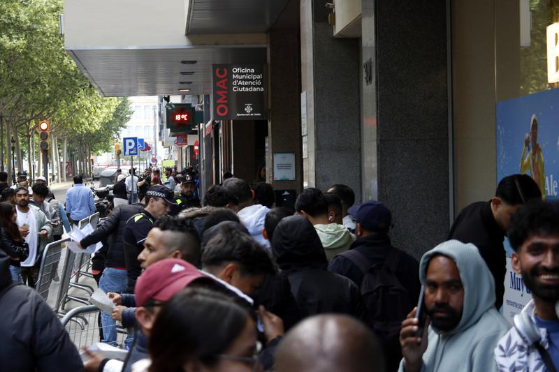 Line of migrants in front of the the Citizen Help and Information Offices on Avinguda Ferran in Lleida.