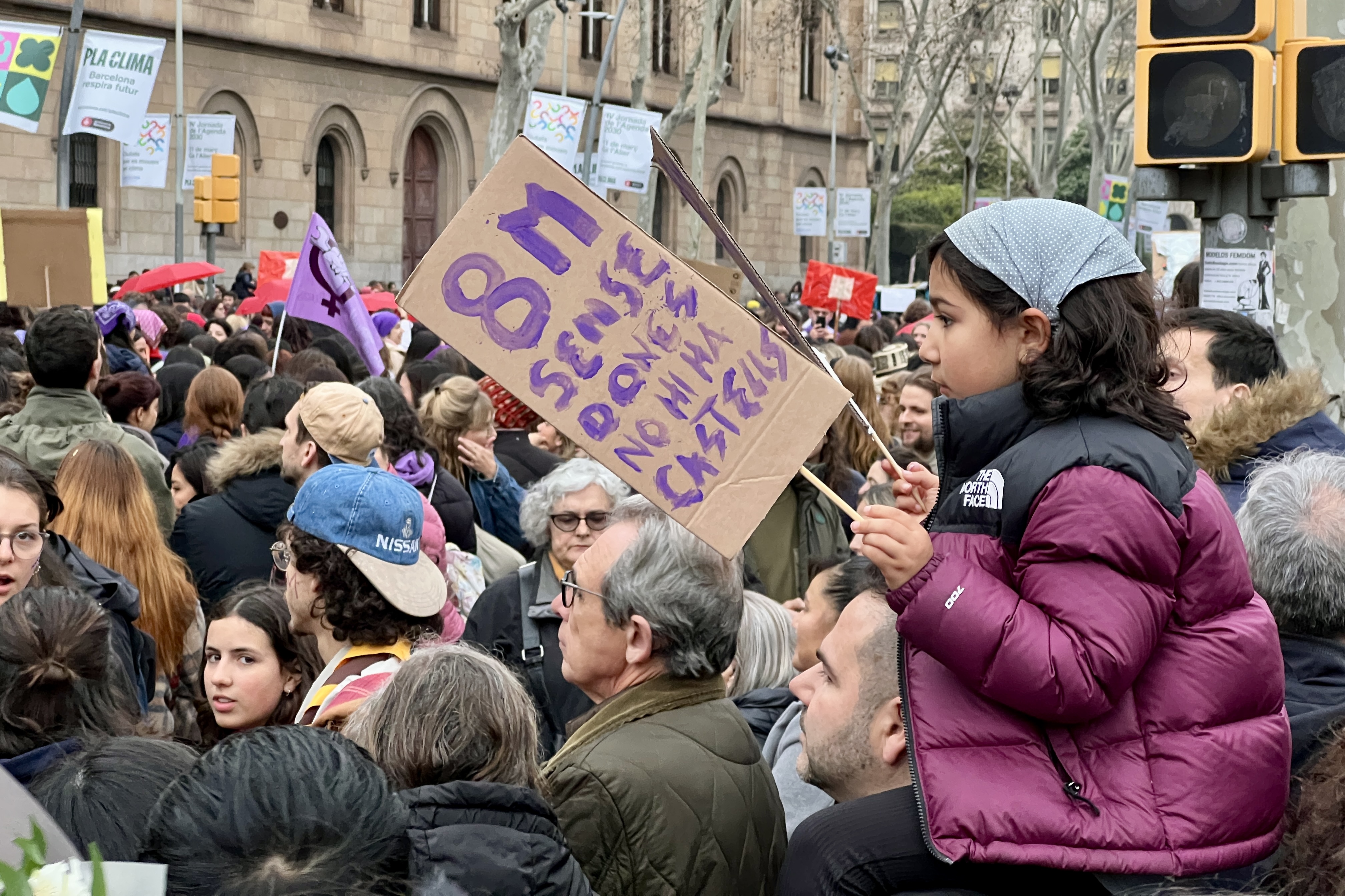 A girl during the 2025 International Women’s Day demonstration in Barcelona holds a poster