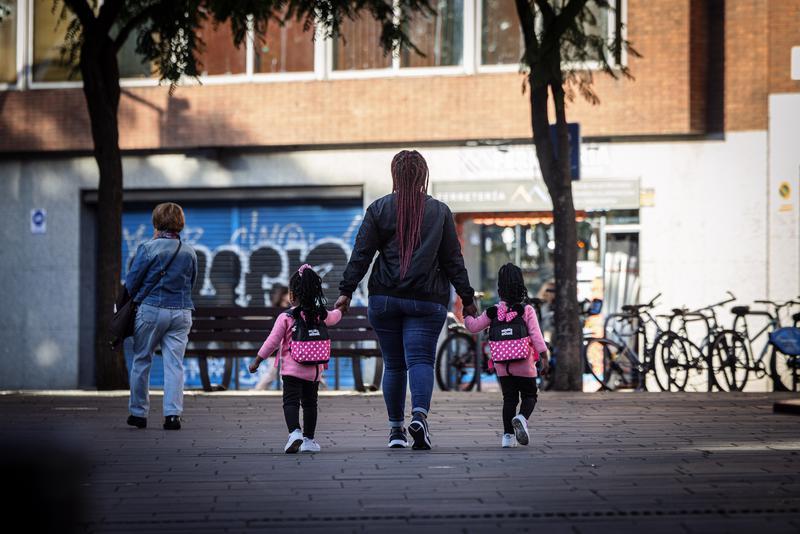 A woman and two children hold hands on a Barcelona street